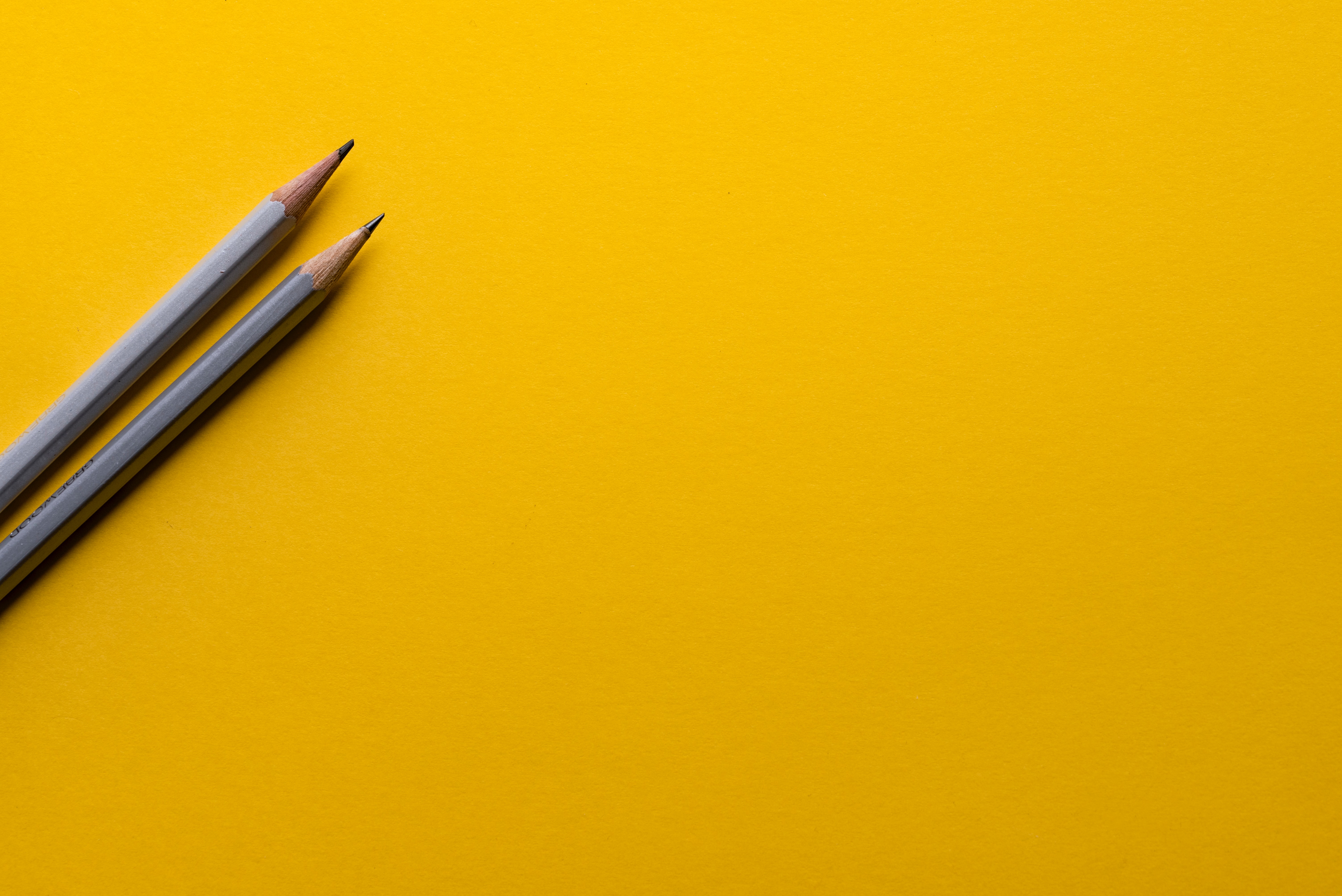 GWi Evaluation zwei Stifte vor gelbem Hintergrund