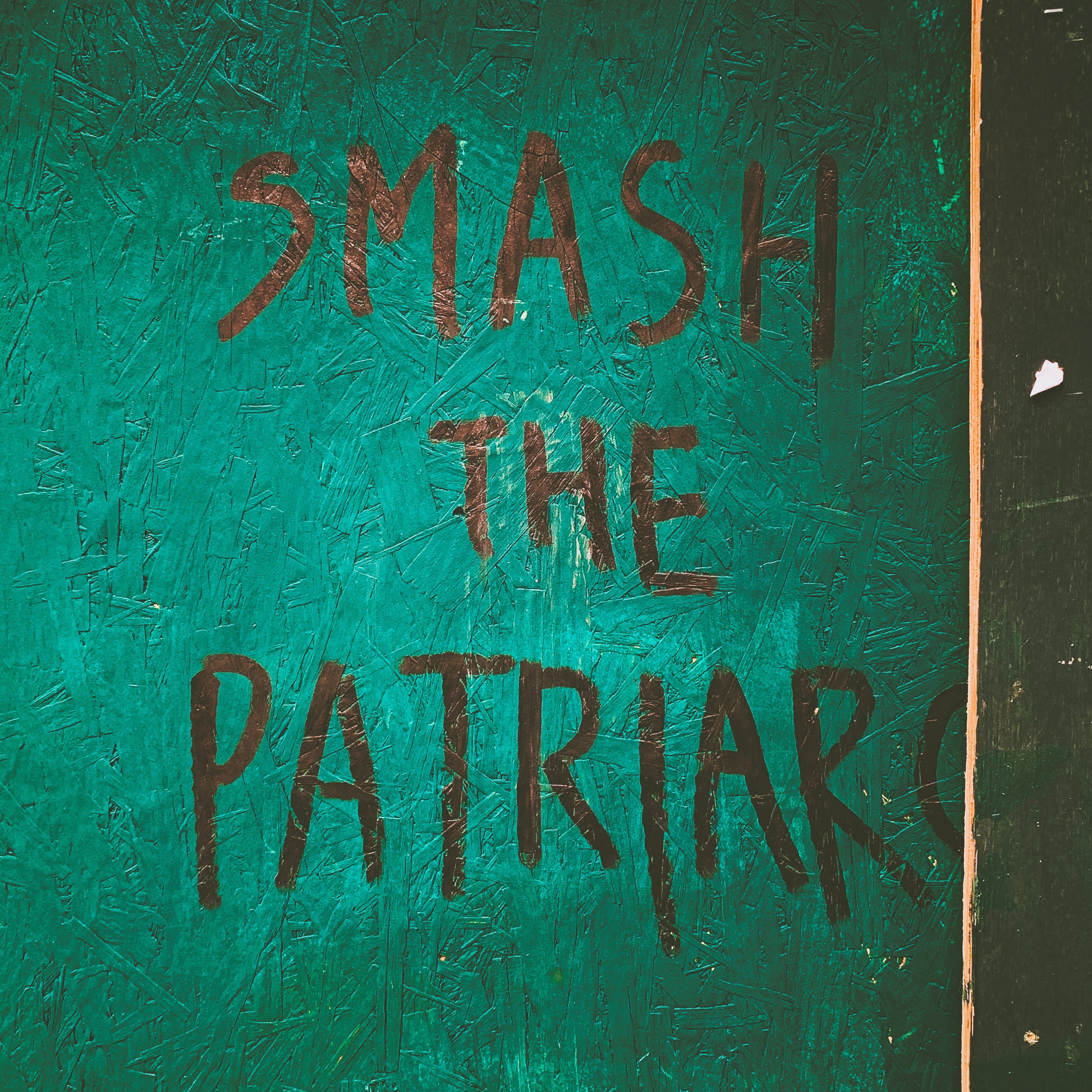 Aufschrift "Smash the Patriarchy" auf grüner Wand