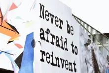 grafitti on wall "never be afraid to reinvent"