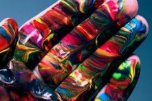 hand with multicolored paint on it