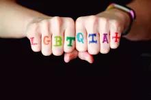 hands with LGBTQIA+ written on knuckles