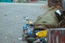 homeless person sleeping in sleeping bag on the ground