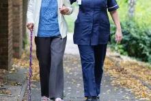 carer taking an older person for a walk