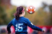 Fußballerin von hinten, die einen Ball annimmt