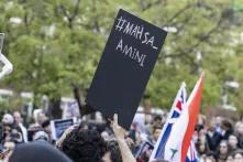 Protests with black sign and caption "#Mahsa Amini"