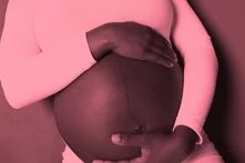 Ein rosa getöntes Bild zeigt den schwangeren Bauch einer Schwarzen Person, die liebend und schützend die Hände darum legt. 