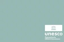 Graugrüner Grund zeigt ich weiss das Logo der UNESCO Logo