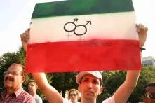 Man holding poster showing Iranian flag and gender symbols