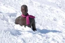 Männerstatue mit rosa Schal im Schnee