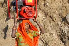 The women of the mountain villages in Rajasthan, India, carry 70 lbs. (or 32kgs) of wood on their heads for cooking every day. This woman is carrying a generator for repair in a nearby village