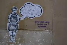 Foto von Streetart. Eine aufgeklebte Frau aus Papier fragt in einer Sprechblase, ob der*die Leser*in Feminist*in sei. 