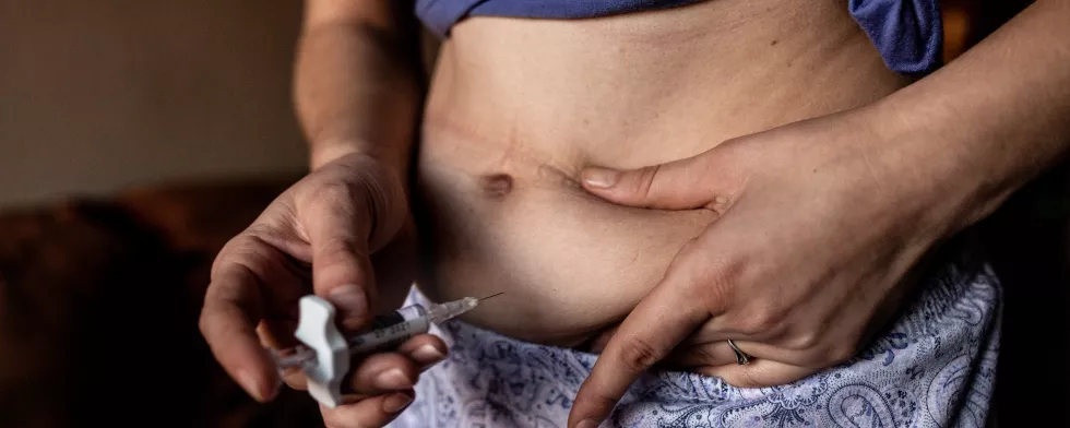 Person zu sehen, die sich eine Spritze in den Bauch gibt