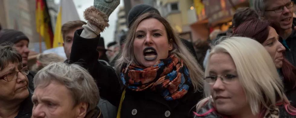 Eine junge Frau reckt ihre Faust in die Höhe auf einem rechtspopulistischen Marsch durch Berlin unter dem Motto: "Wir sind kein Freiwild, Nirgendwo!!!"