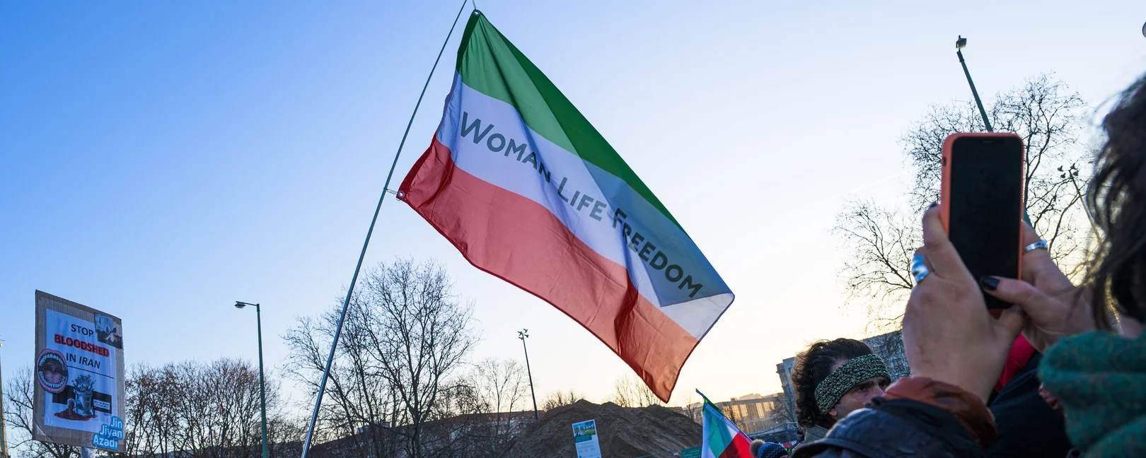 Eine grün-weiß-rote Flagge des Irans mit dem Schriftzug 