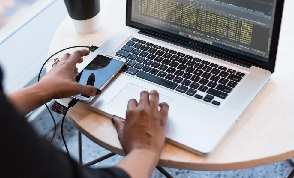 hands on computer and phone