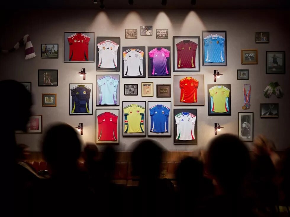 Eingerahmt an einer Wand hängen verschiedene Trikots für die anstehende Fußball-EM 2024.