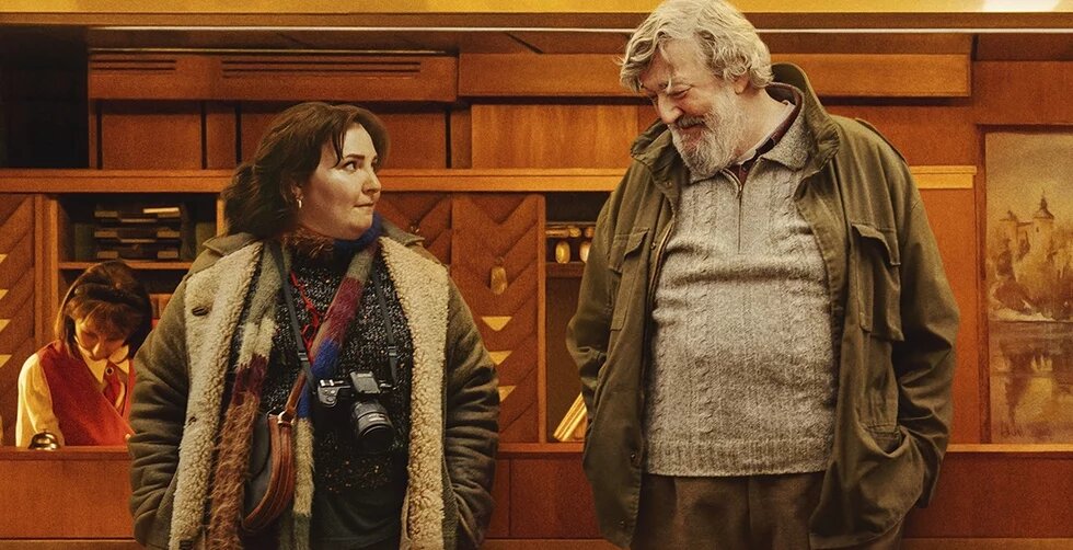 Filmstill Treasure Zwei erwachsene Personen schauen sich wertschätzend an. Es besteht ein Generationsunterschied: die weiblich gelesene Person links ist etwa in ihren 30ern, der Mann neben ihr ist um die 70 Jahre alt. Es ist eine Szene aus dem Film Treasure.