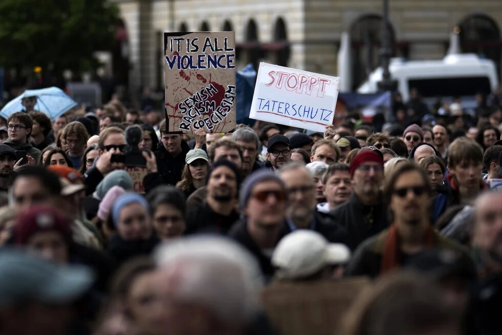 Demonstrant*innen mit Schildern "It is all violence: Sexism, Racism, Speciesism" und "Stoppt Täterschutz" auf der Kundgebung und Demonstration gegen sexualisierte Gewalt an Frauen.