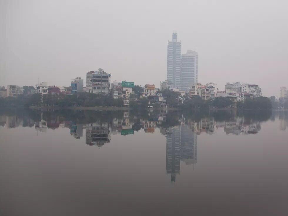West Lake aka Hồ Tây - Hanoi, Vietnam. Aufgenommen von Chris Goldberg Skyline Hanoi vom Hô Tai-See aus. Es ist nebelig