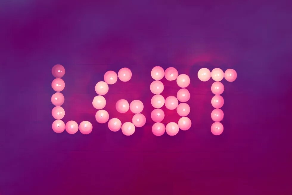 LGBT LGBT written with tealights on purple ground