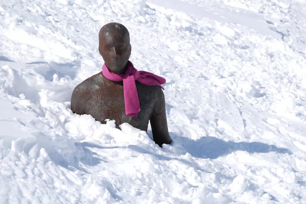 Was bedeutet Männlichkeit? Männerstatue mit rosa Schal im Schnee