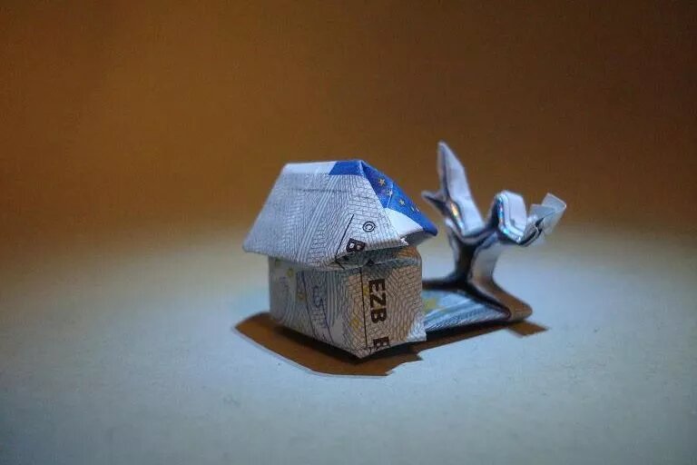 Foto von einem aus einem Geldschschein gefalteten Haus