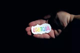 piece of paper on hand, which says LGBTQIA