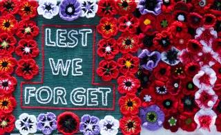 Stickerei mit Blumen und "Lest we forget"