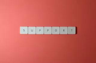 Das Wort "Support", gelegt aus weißen Buchstaben auf rotem Hintergrund