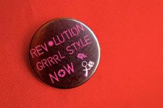 Button mit "Revolution grrrl style now!" Aufschrift