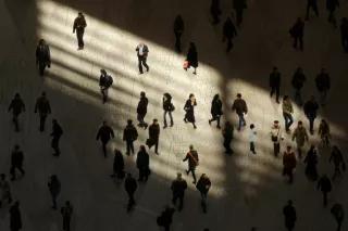 „Die Prämisse der Flexibilisierung der Arbeitsmärkte, die zunehmende Deregulierung und die Erhöhung von Anreizen in Niedriglohnbranchen erhöhen unsichere Arbeitsverhältnisse.“ Menschen in Licht und Schatten auf einem Platz