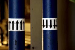 Es scheint, dass die Herausforderungen, vor denen Gleichstelluungsaktivist_innen heute stehen, durch die Finanzkrise und Austeritätspolitik noch deutlich verstärkt wurden Zwei Stangen mit Stickern "Hoch" und "Runter".