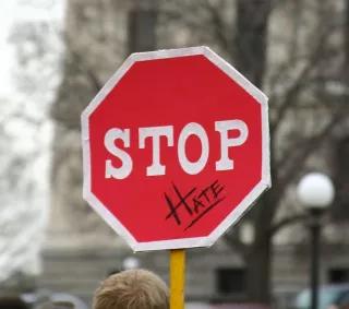 Hate Speech und Gewalt im Internet zeigen, dass es Handlungsbedarf gibt Schild mit "Stop Hate"