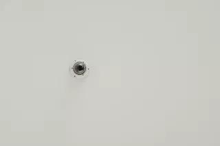 Surveillance camera on white wall.