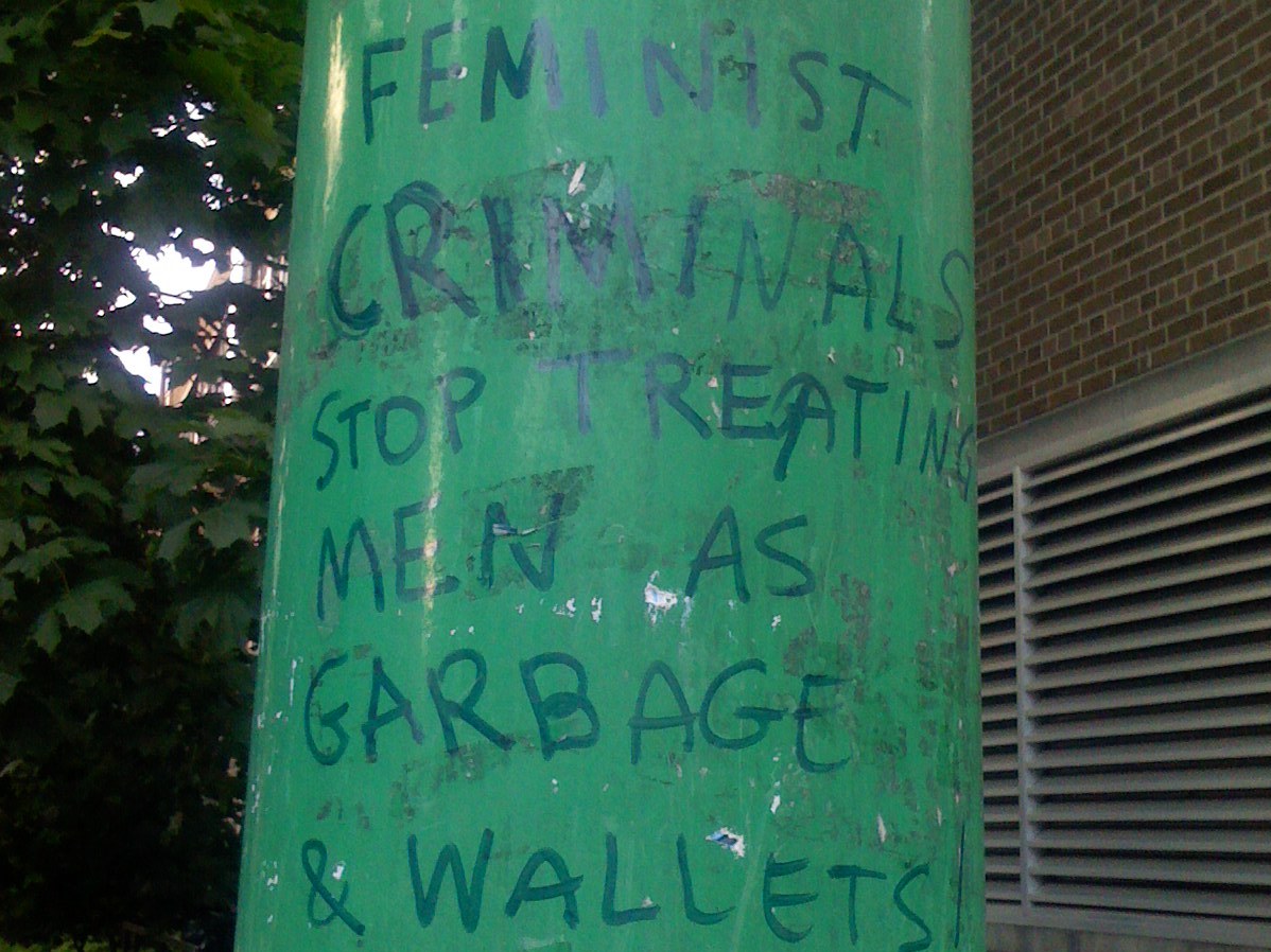 Feminist Criminals Antifeministische Parole auf Litfaßsäule, in grün und blau