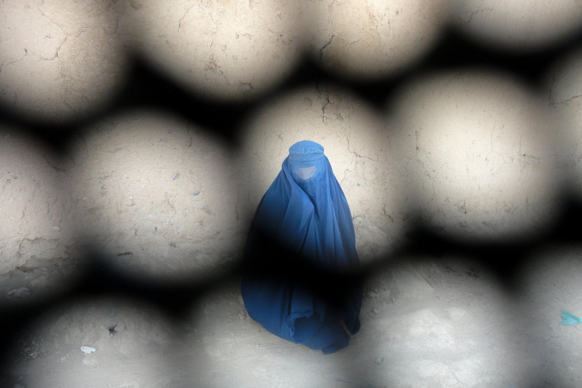 Although the overthrow of the Taliban opened up new opportunities for women, it did not give rise to the “women’s liberation” many were expecting Woman burka photographed through the mesh of a burka